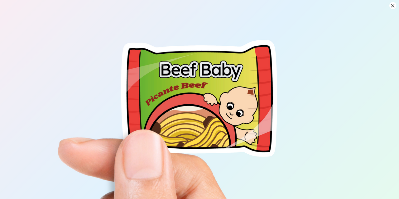 woman holding Brooklyn nine nine inspired Rectangular vinyl sticker featuring a cartoon baby emerging from a green and red package labeled "Beef Baby" and "Picante Beef" in a bold, vibrant illustration style.