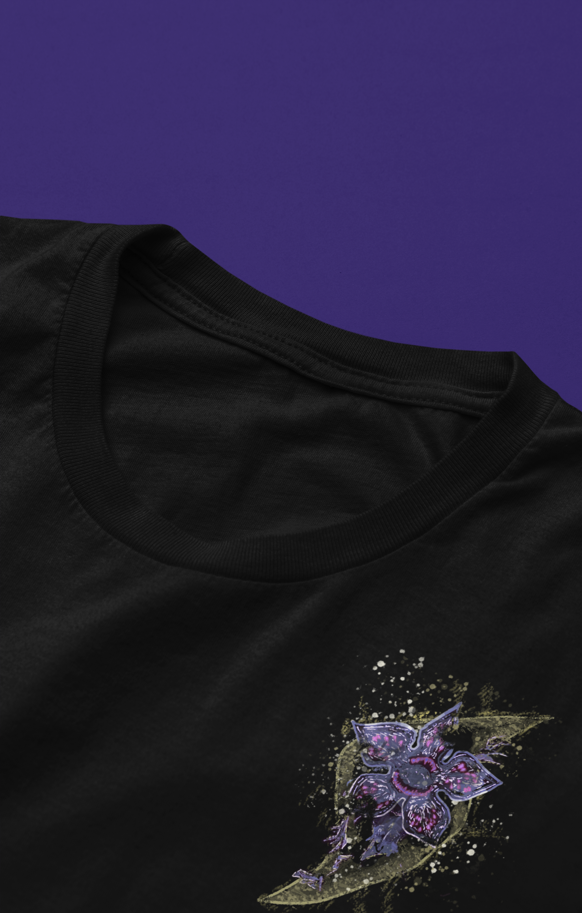 Black t-shirt, featuring a detailed purple and gold pattern, with a lightning bolt pattern on the chest with a Stranger Things inspired character popping out 
