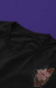 Black t-shirt , featuring a detailed red and gold abstract design with a lightning bolt pattern on the chest with a Stranger Things inspired character popping out 