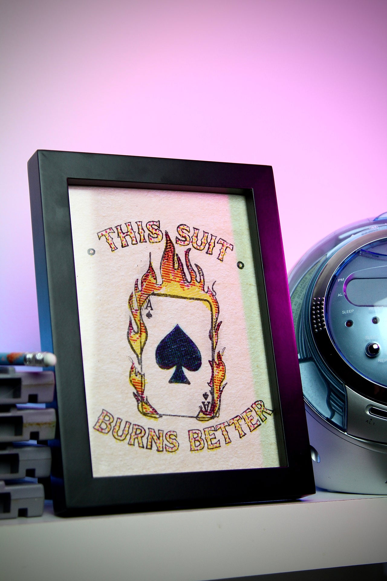 Framed artwork with a spade symbol and text on a purple background